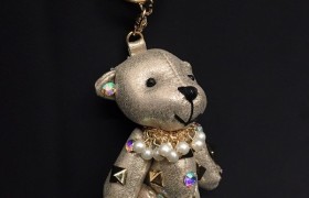 Orso imbottito portachiavi tessuto irridescente con applicazioni strass e borchie. CM 13