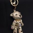 Orso imbottito portachiavi tessuto irridescente con applicazioni strass e borchie. CM 13